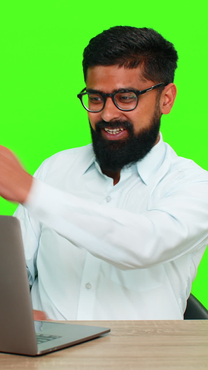 Indian man raising arms with smile looking at laptop celebrating jackpot win or good news surprise