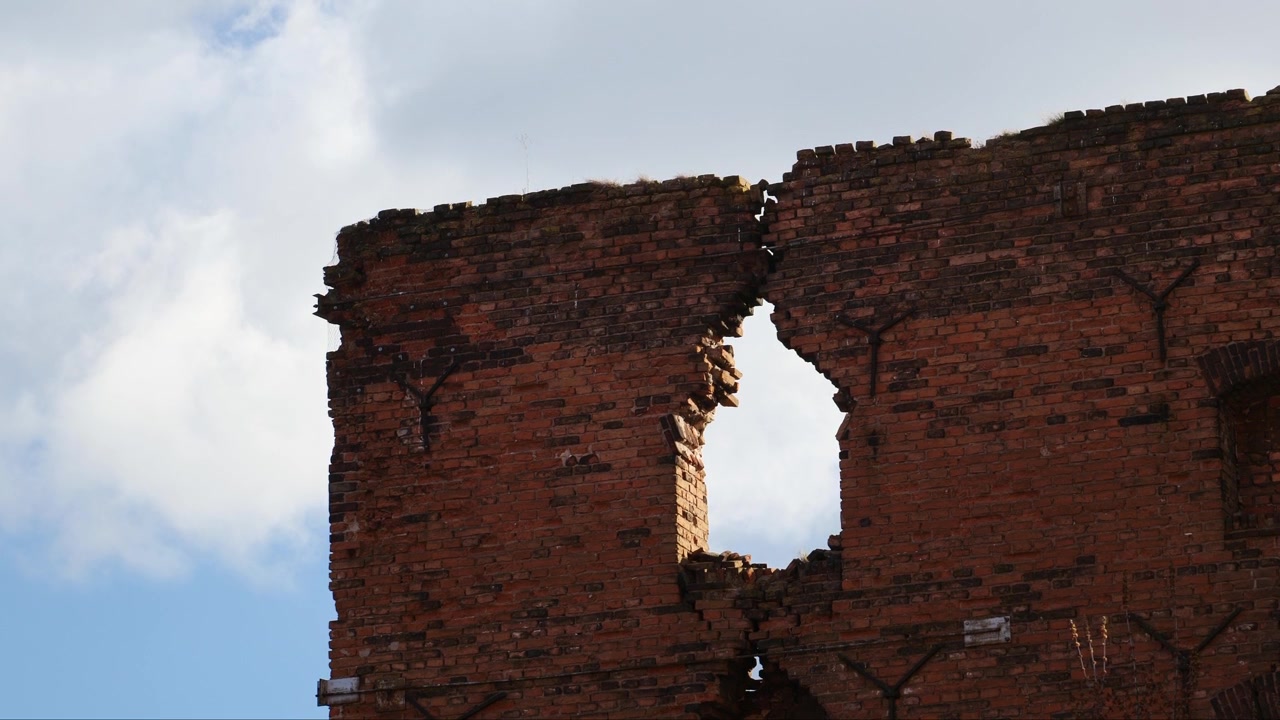 Muro de ladrillo en ruinas en un almacén abandonado. Gaviotas volando alrededor. Gdansk, Polonia.