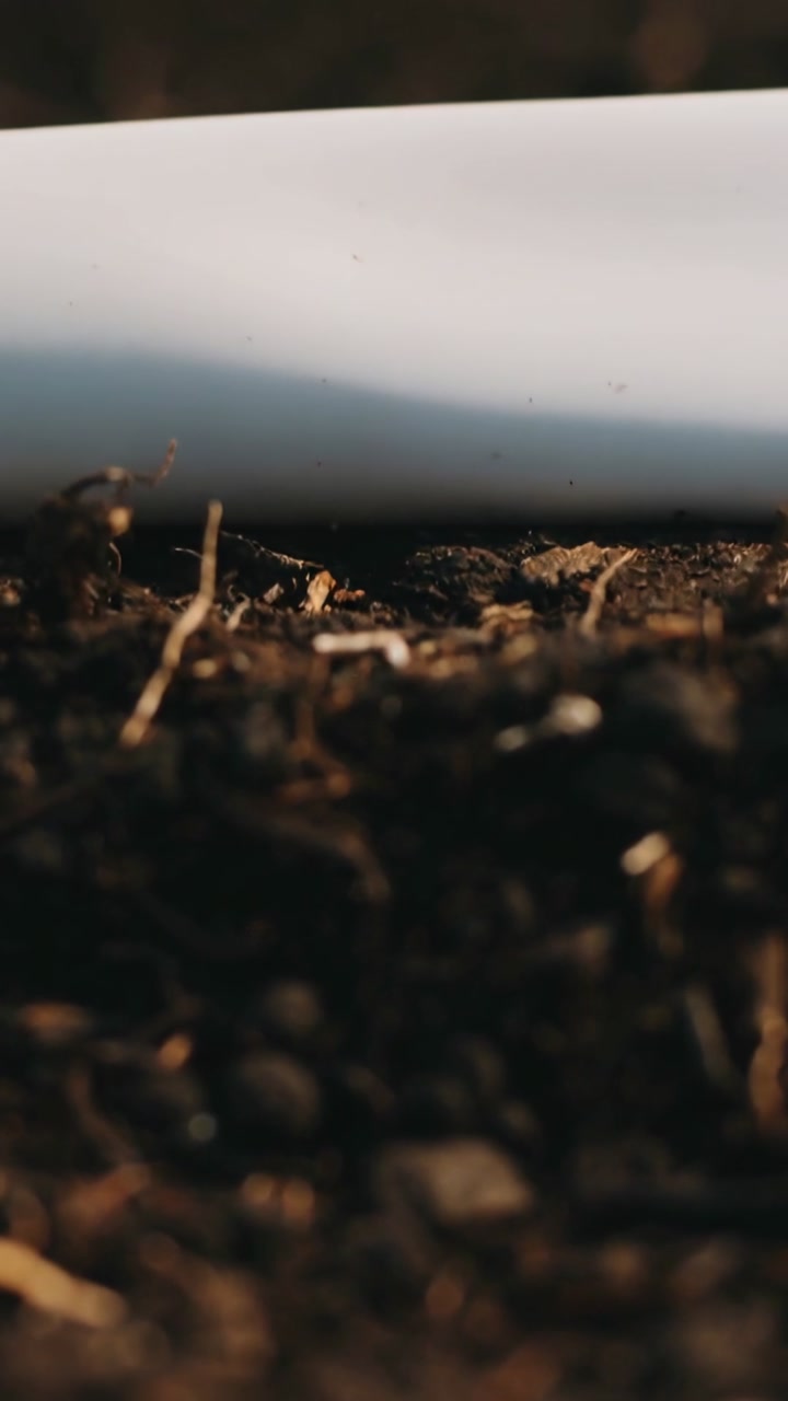 Vertical video: Potting mix showing texture, focus shifting upward revealing planter rim for garden