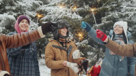 friends celebrating christmas in winter forest