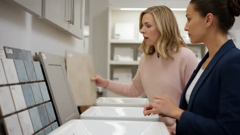 two women choosing tiles and cabinets