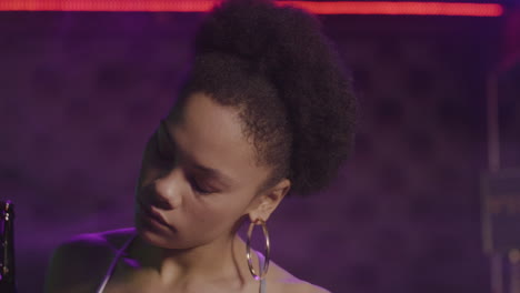 close up of an attractive girl drinking beer and dancing at disco