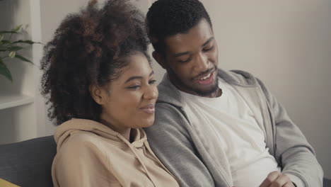 young couple having fun while watching a movie on tv 1