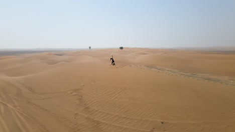 Mujer-Con-Hula-Hoop-Caminando-Sobre-Una-Duna-De-Arena