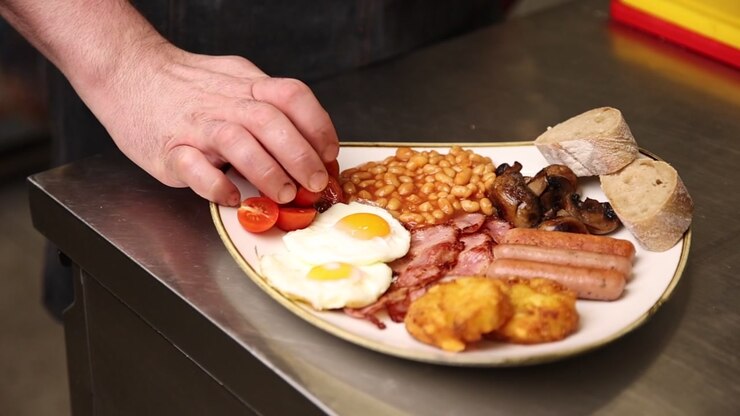 Chef Arranging a Traditional Full English Breakfast Plate