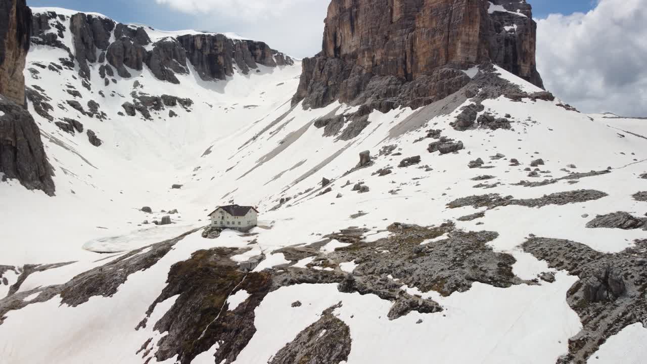 Aerial Drone Shot on House in the mountain in a snowy valley-Pisciadù Hut in Alta Badia