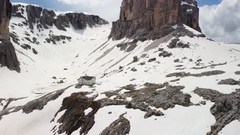 aerial drone shot on house in the mountain in a snowy valley-pisciadù hut in alta badia