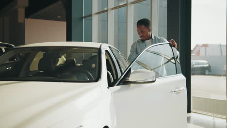 man checking out a new white car in a showroom