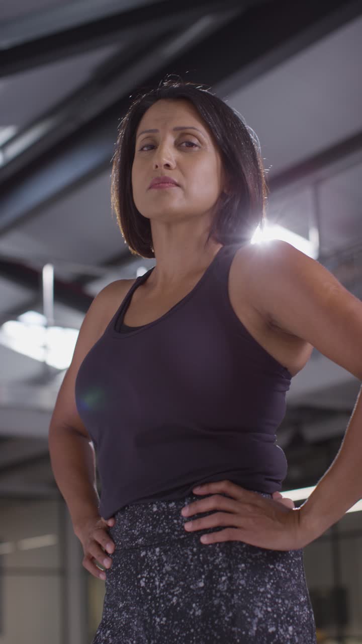 Vertical Video Portrait Of Mature Woman Wearing Fitness Clothing Standing In Gym Ready To Exercise 1