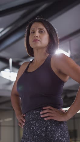 Vertical-Video-Portrait-Of-Mature-Woman-Wearing-Fitness-Clothing-Standing-In-Gym-Ready-To-Exercise-1