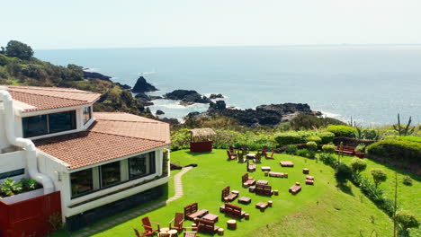 cinematic aerial drone shot of a beautiful resort located on top rocky coastline in sao miguel island, azores - portugal