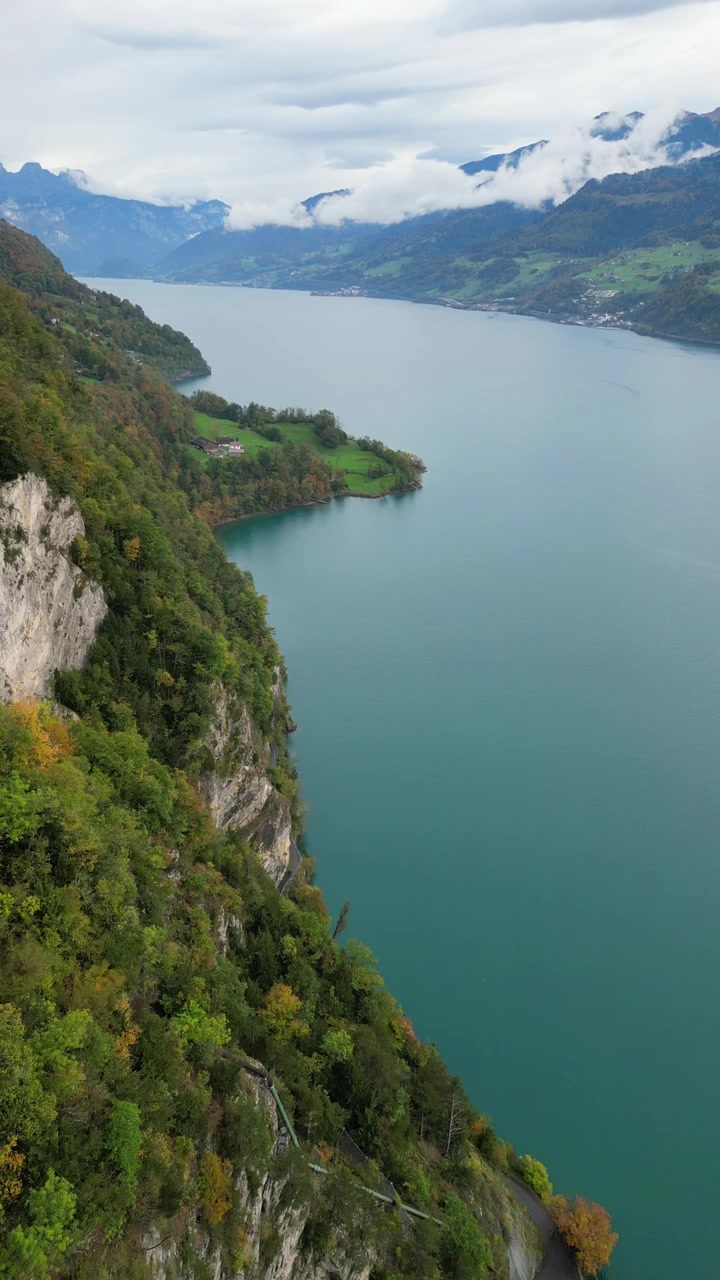 Walenjärven (Walensee) ilmakuva dronella: jyrkkä kallioinen laaksonäkymä, pystysuuntainen video Euroopan luonnosta.