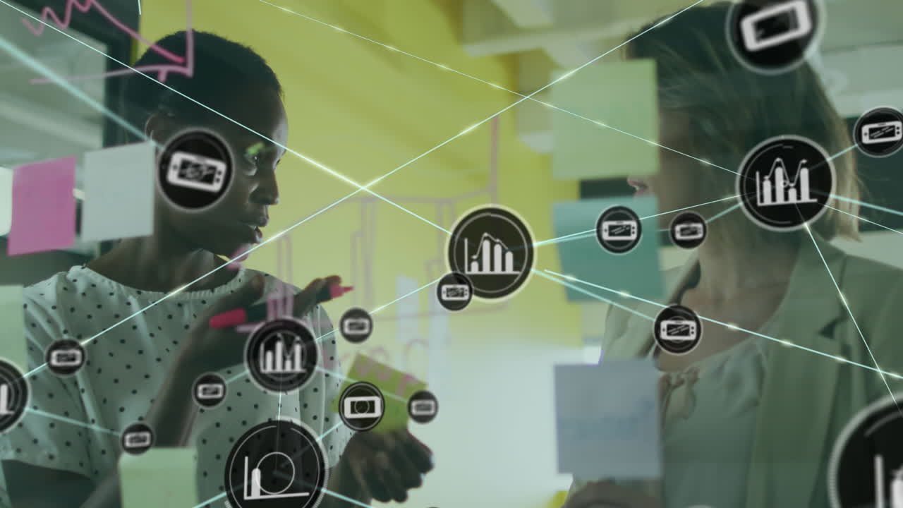 Animation of connected icons over diverse female coworkers discussing strategy on sticky notes