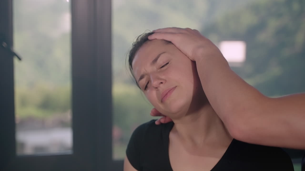 통증 완화를 위해 목과 머리 마사지를 받는 여성