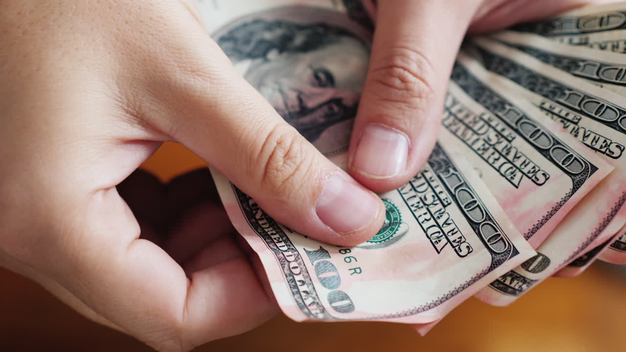 Inspecting Damaged 100 USD Banknotes