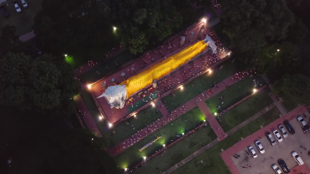 vista a vista de pájaro de las personas caminando con la luz de las velas alrededor de la imagen de bigh buddha