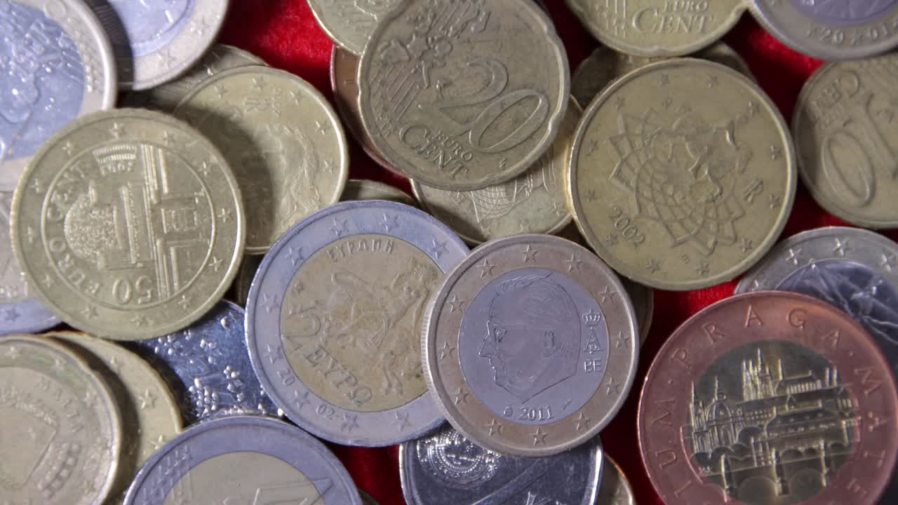 vista superior de las monedas de los países europeos en un paño rojo, primer plano, el concepto de ingresos y éxito empresarial.