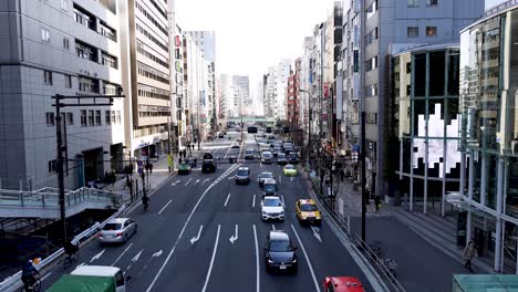 traffic and pedestrians at a busy city crossroad.