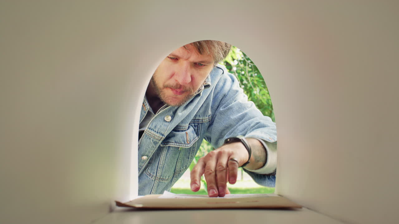 Man Picking Up Letters from Mailbox Outside on Summer Day