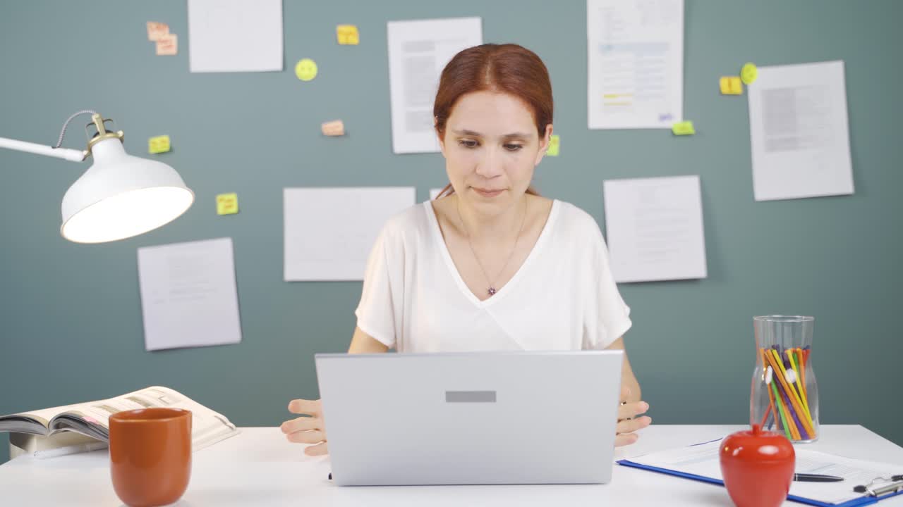 Woman closing laptop with angry expression.