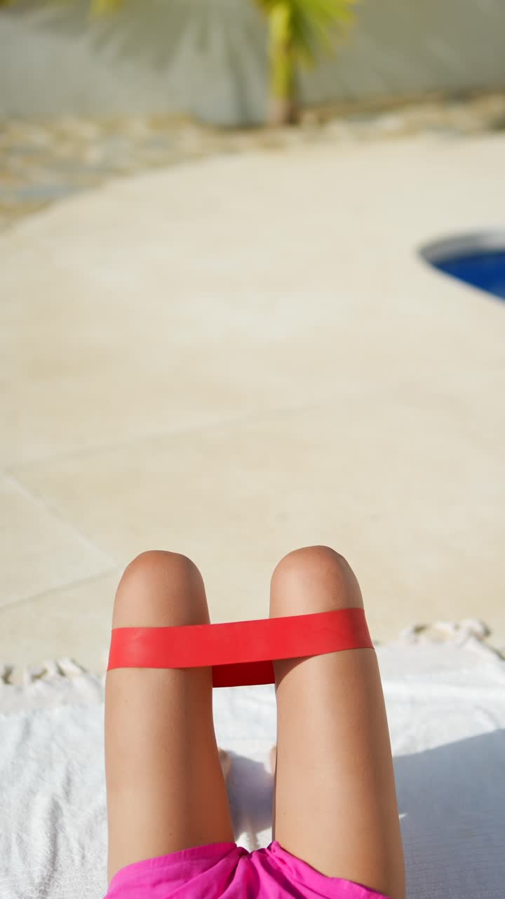 Donna che fa esercizi per le gambe con elastici di resistenza a bordo piscina