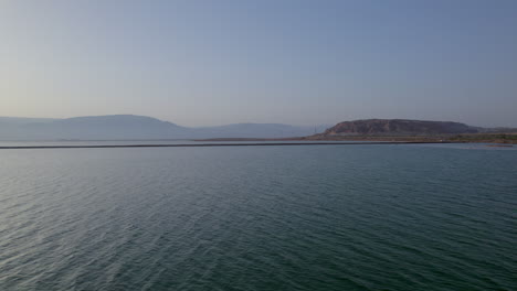 Pull-back-drone-shot-over-the-Dead-Sea-with-the-Jordan-mountains-in-the-background