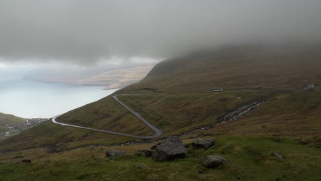 全景圖顯示巴士在山路上下坡到山谷的funningur鎮,背景是funningsfjord