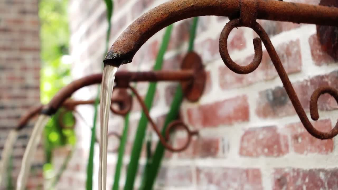 agua que fluye de una tubería rústica