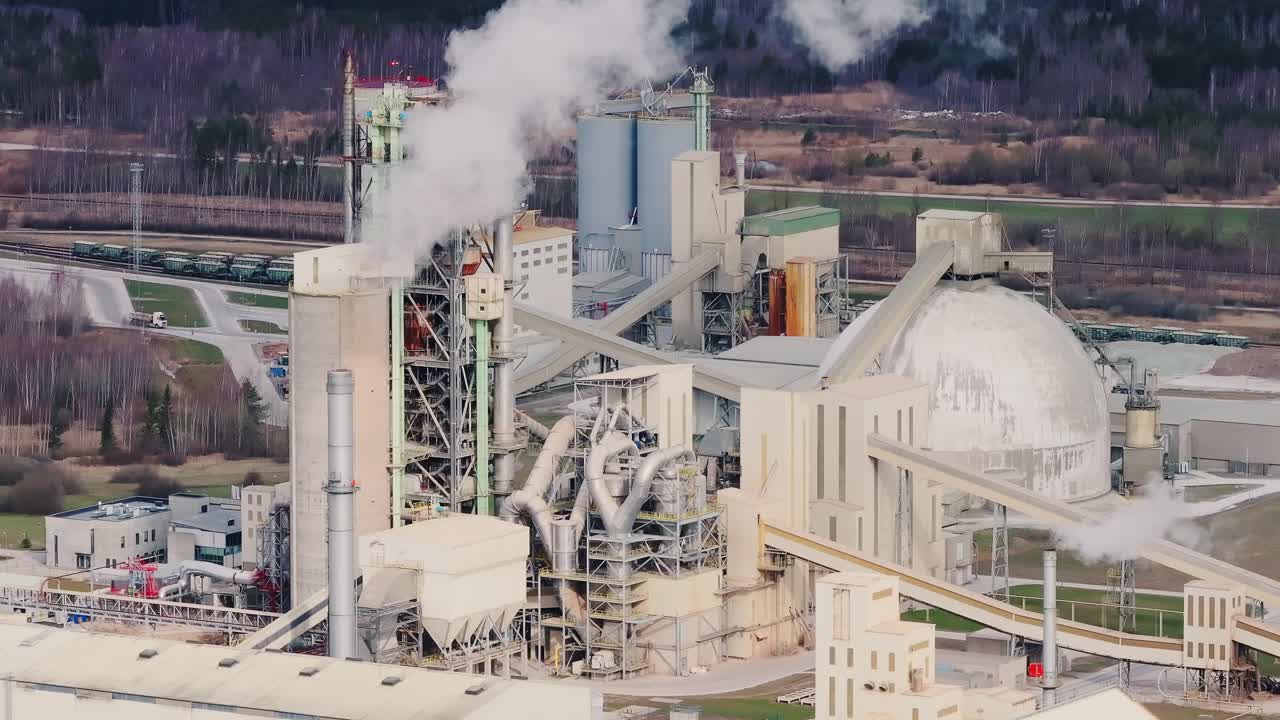 Overcast sky shadows sprawling cement plant in Latvia during early spring