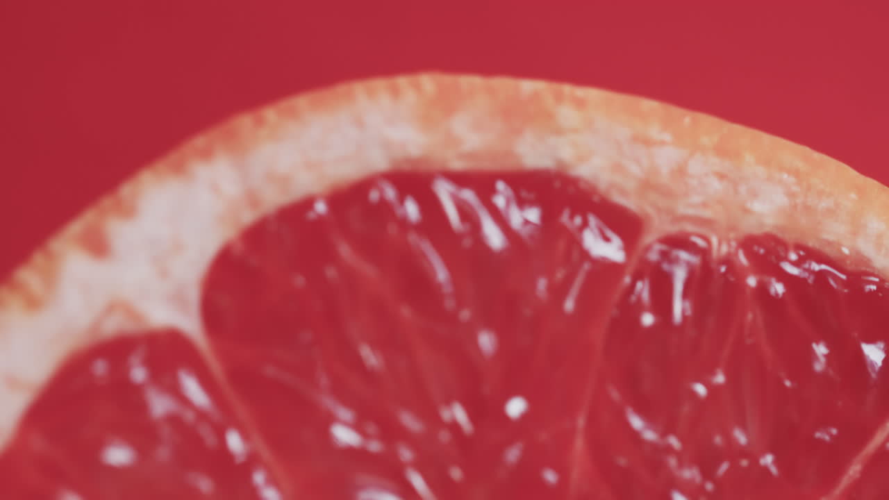 Video of sliced red grapefruit with copy space over red background