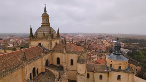 aerial view of segovia cathedral and city during winter cloudy morning with snow flakes falling