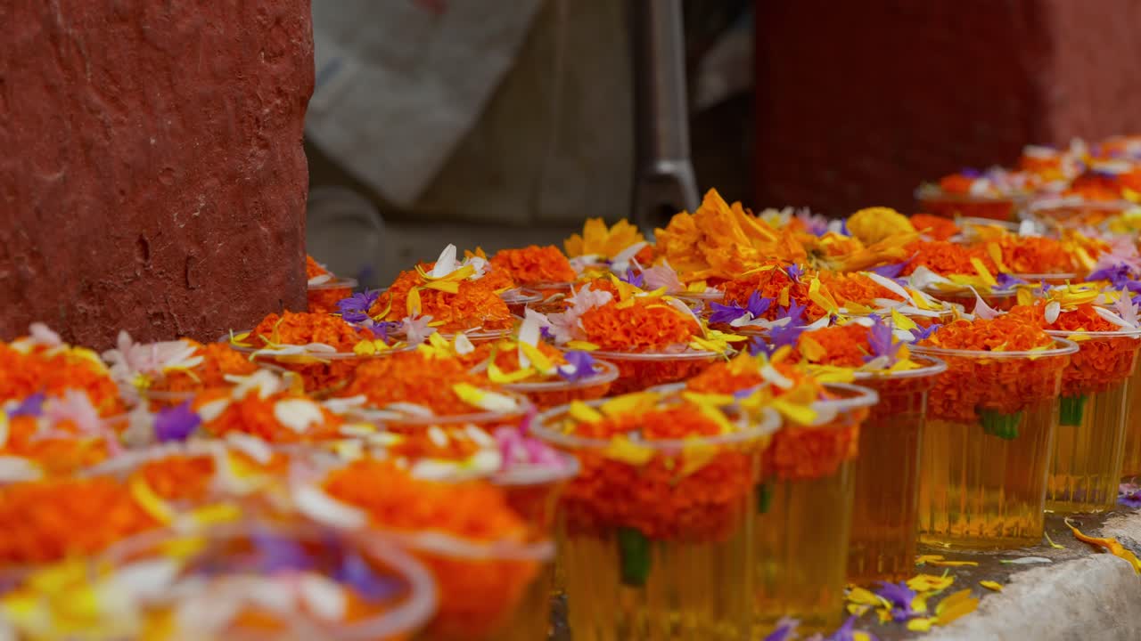 clip de panorámica de filas de ofrendas de flores para la venta fuera del templo en katmandú, nepal