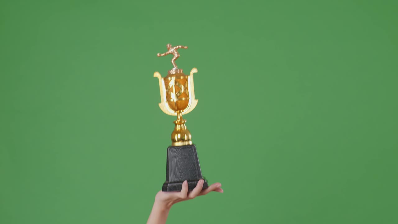 hombre sosteniendo un trofeo de oro campeón. fondo de pantalla verde
