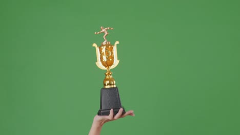 man holding a champion golden trophy. green screen background