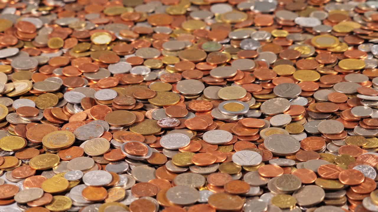 Coins of different sizes and colors spread on a flat surface