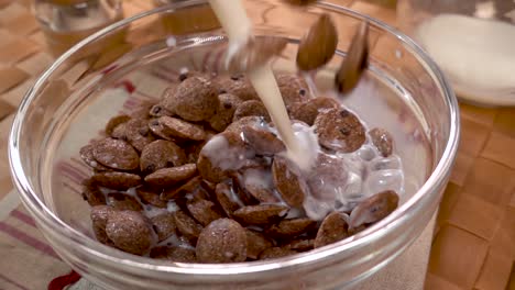 copos de chocolate crujientes en un tazón para un delicioso desayuno matutino con leche. cámara lenta con toma de seguimiento de rotación.