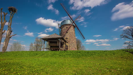 Iconic-stone-millhouse-building-against-blue-sky-and-cloudscape,-time-lapse