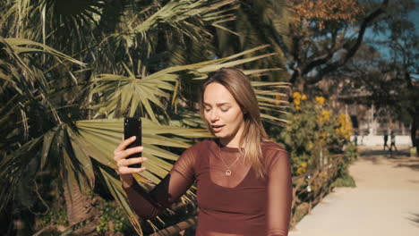 beautiful blonde woman with blue eyes recording video message.