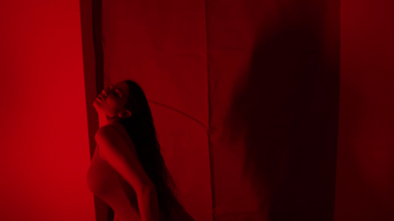 impresionante actuación de luz roja por una hermosa bailarina sola en una habitación