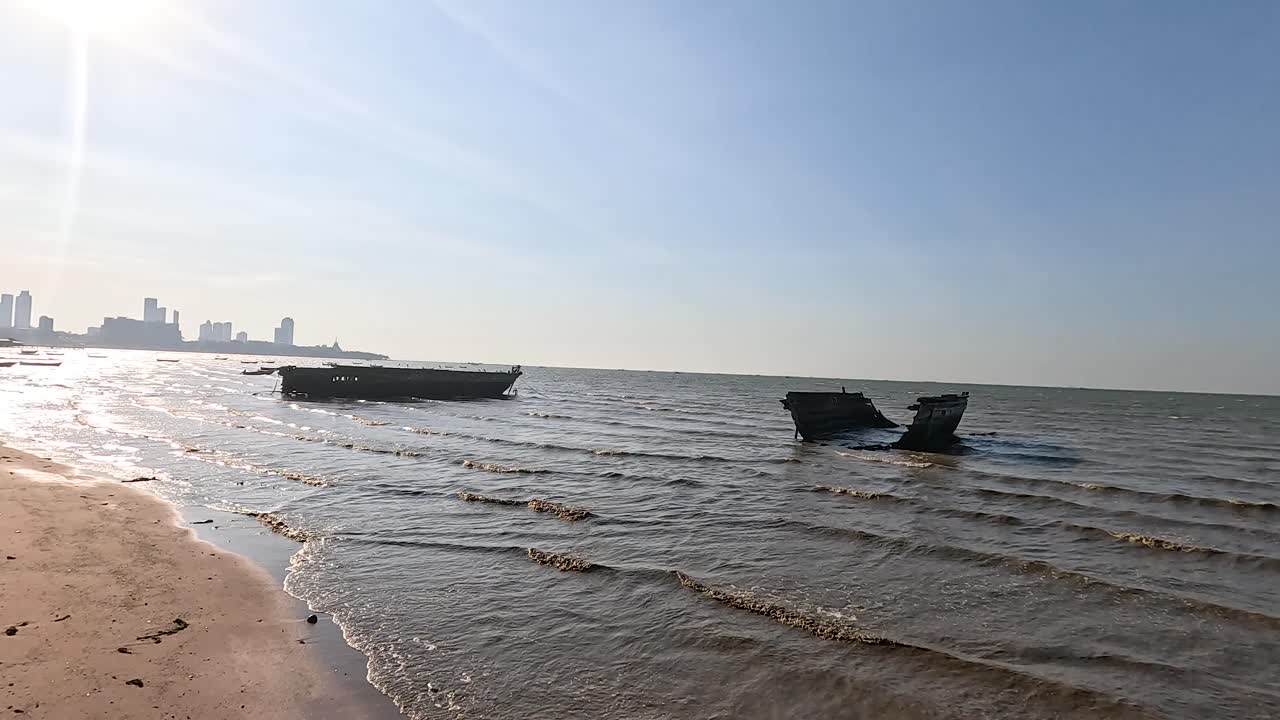 해가 지면 파도가 파손된 배에 부히고