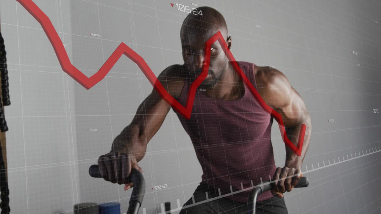Mature man gripping handles and pedaling hard in gym, red graph overlaying torso tracking metrics