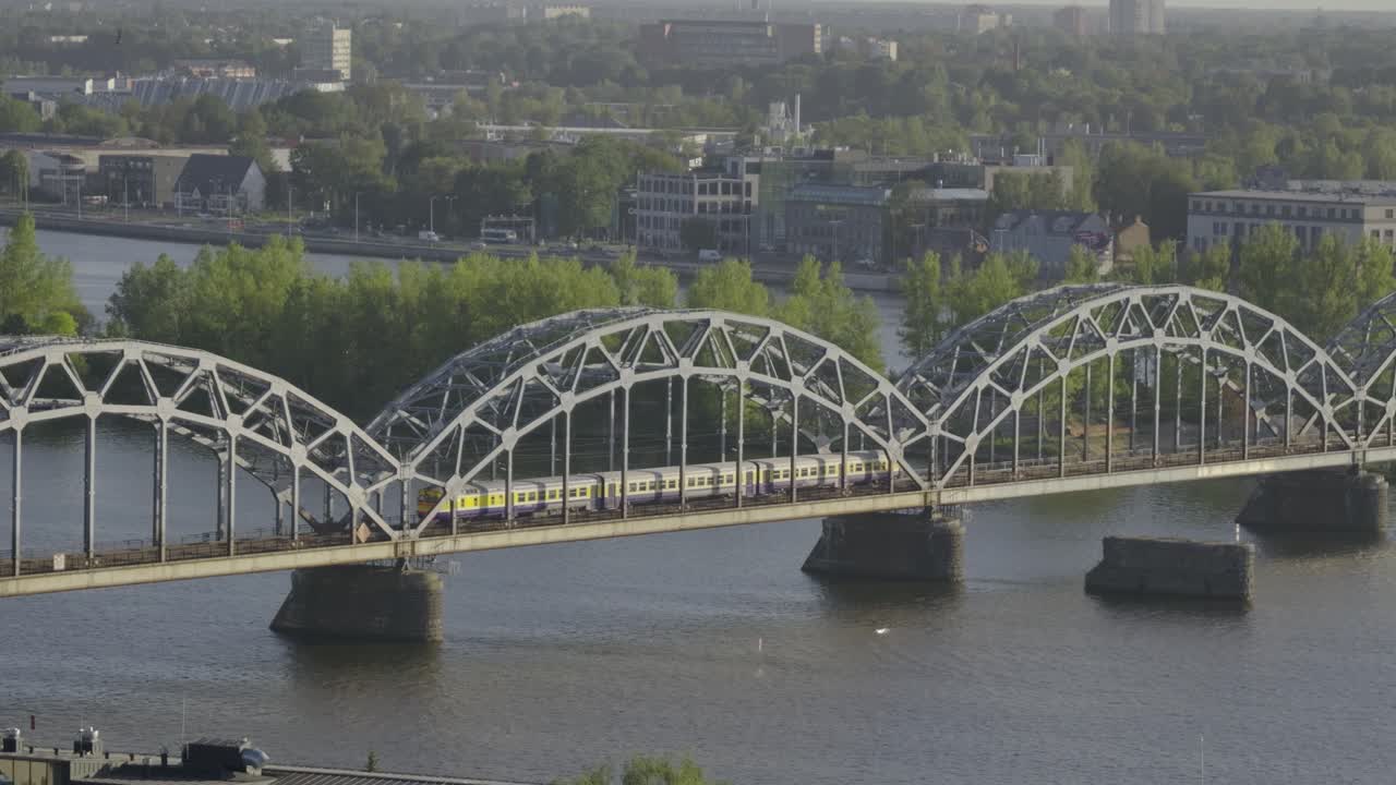 Train passing over arched bridge inside European city
