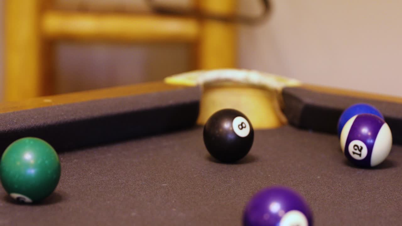 ocho bolas golpeando y disparando la bola número 5 en el bolsillo de la esquina en la mesa de billar