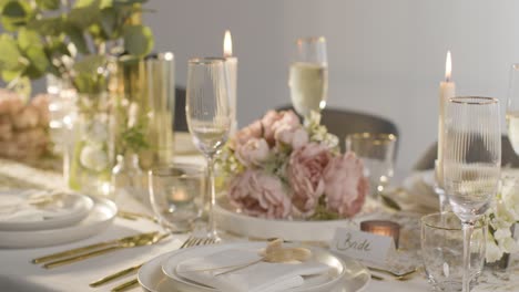 primer plano de una persona vertiendo champán en un vaso en la mesa preparada para la comida en la recepción de la boda 1