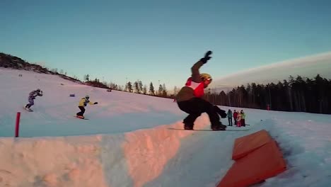 snowboarders at a winter sports park at sunset