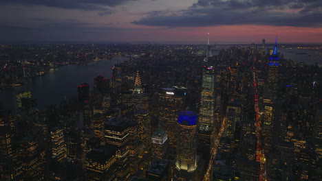 Aerial-panoramic-footage-of-downtown-development-at-dusk.-Lighted-windows-of-high-rise-buildings-and-colourful-twilight-sky.-Manhattan,-New-York-City,-USA