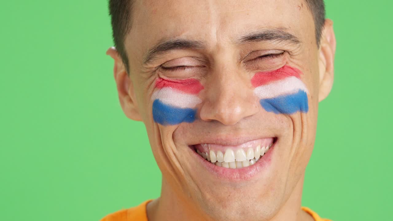Man with a dutch flag painted on the face smiling
