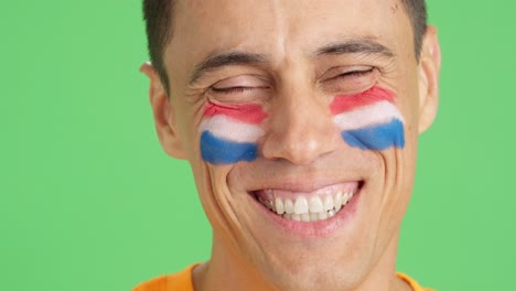 man with a dutch flag painted on the face smiling