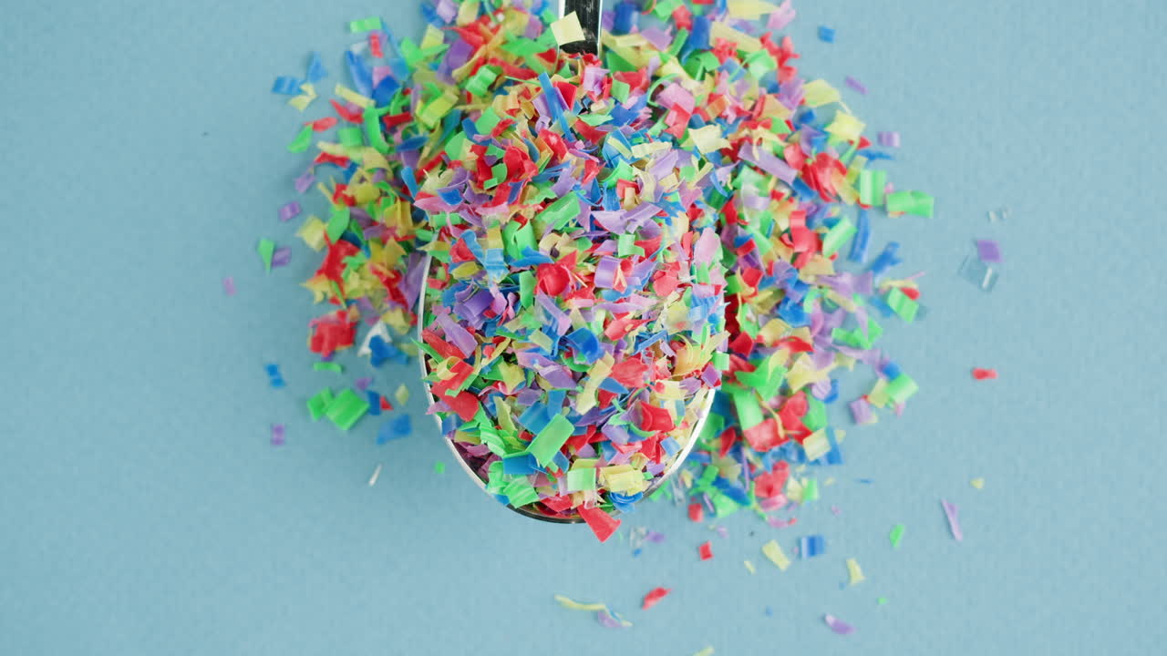 Pezzi di plastica riciclata colorati in un cucchiaio
