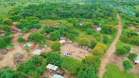 drone flying over a village with a car driving towards it